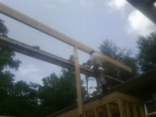 Carpenter setting a ridge beam over a new addition frame — Ice Dam Removal by Roofing Brothers in Rose Hill