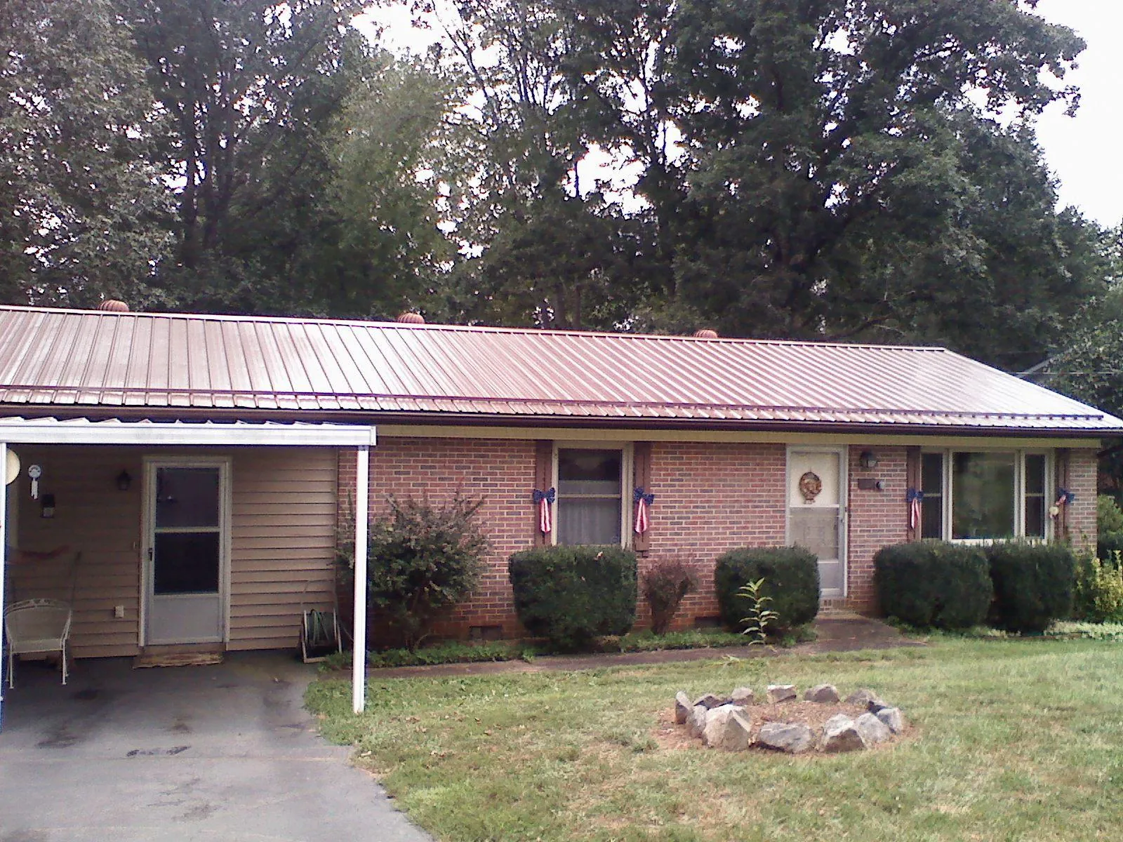 Bronze metal roof and carport on a brick ranch home — Roof Repair work by our crew in Rose Hill