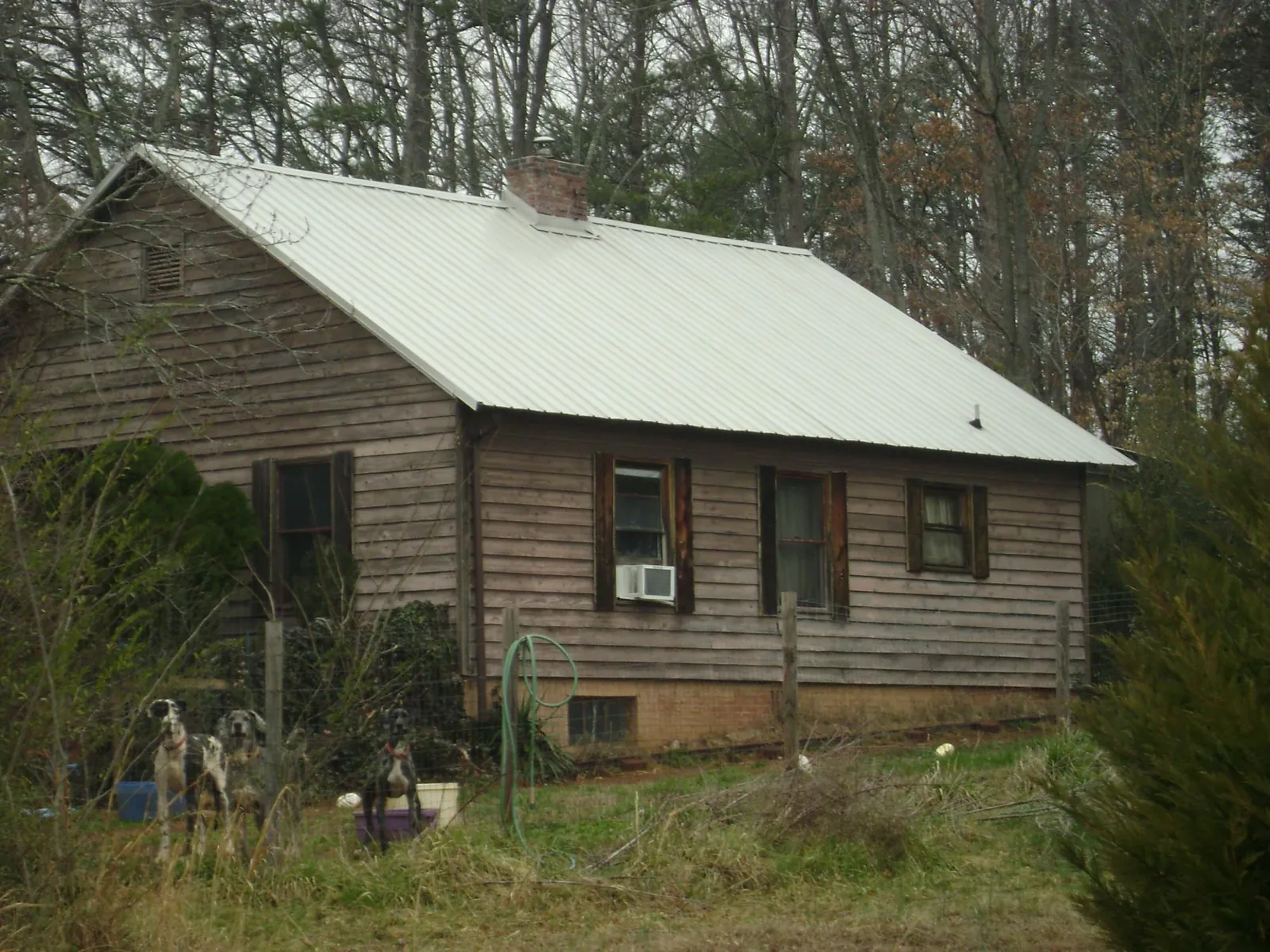 White metal roof on an old wood sided farmhouse, from a Metal Roof Installation job in Rose Hill